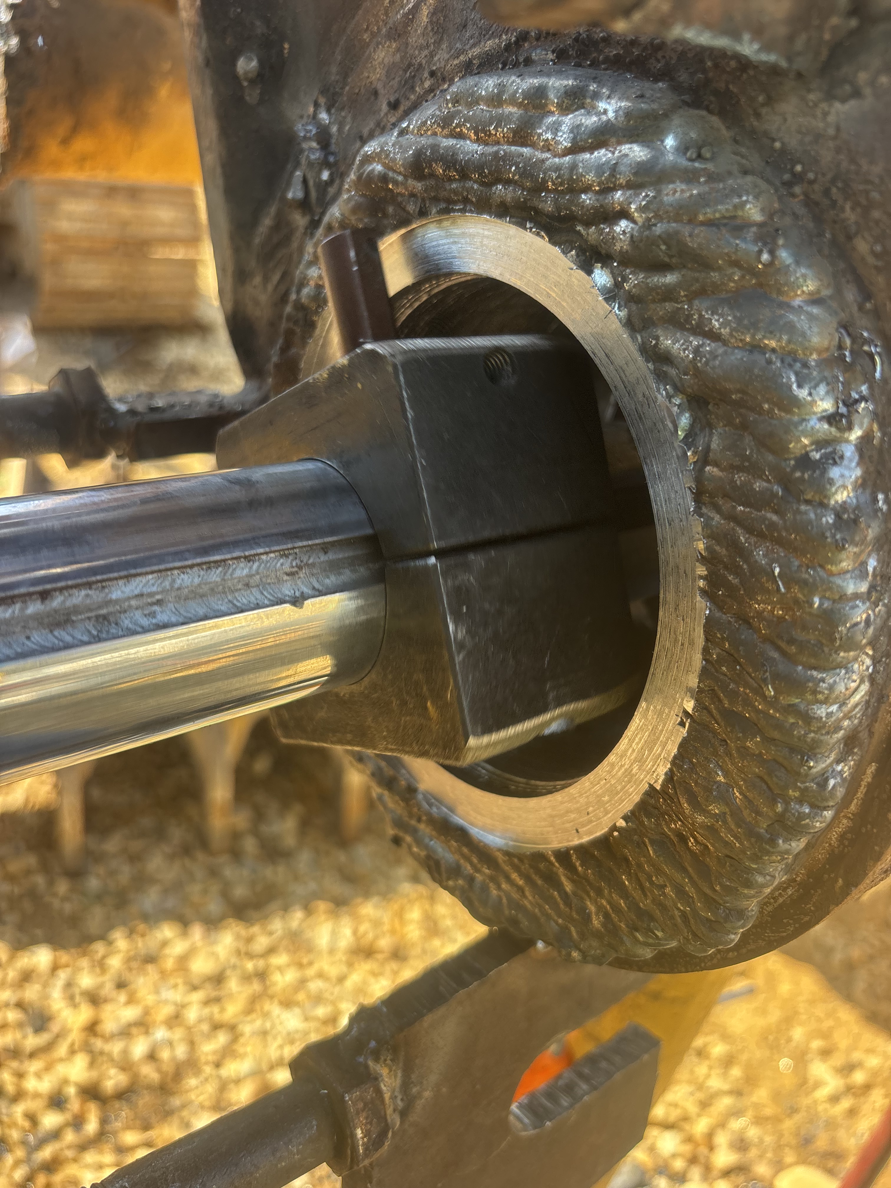 Close-up of a freshly welded and bored metal cylinder with visible weld bead